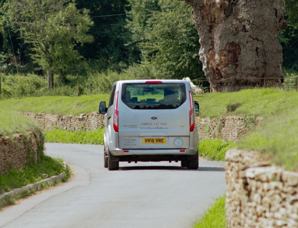 Outside shot of the In and Beyond Bath van driving down a narrow road through the Cotswolds