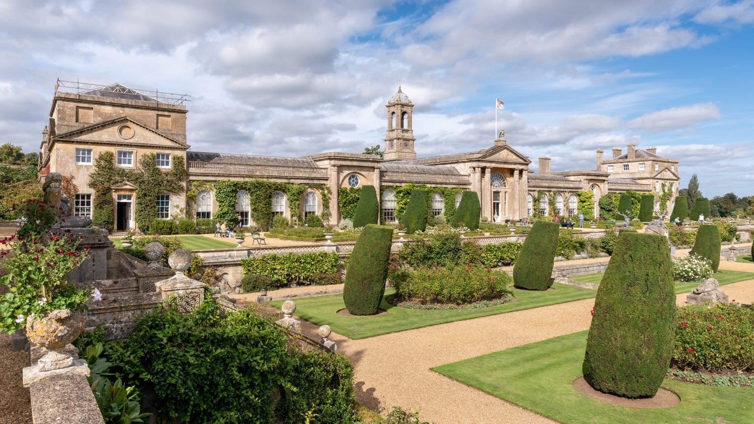 Bowood house from the corner of the garden, pruned hedges and grass verges in the foreground