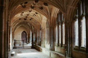 An old corridor that looks like it belongs in a church or Oxford. The architecture is decadent and ornamental.