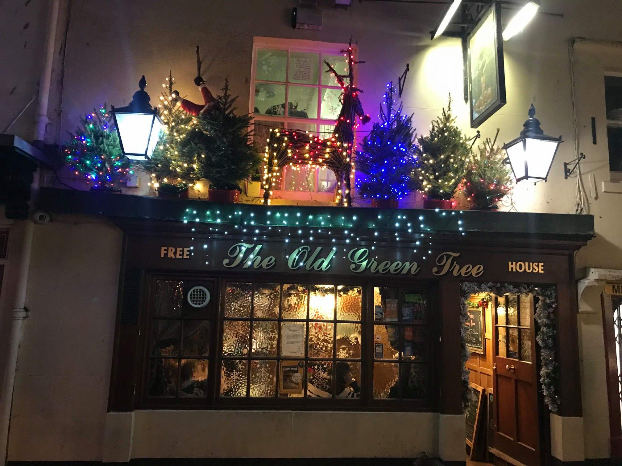 The Old Green Tree pub outside facade at night with Christmas light decorations.
