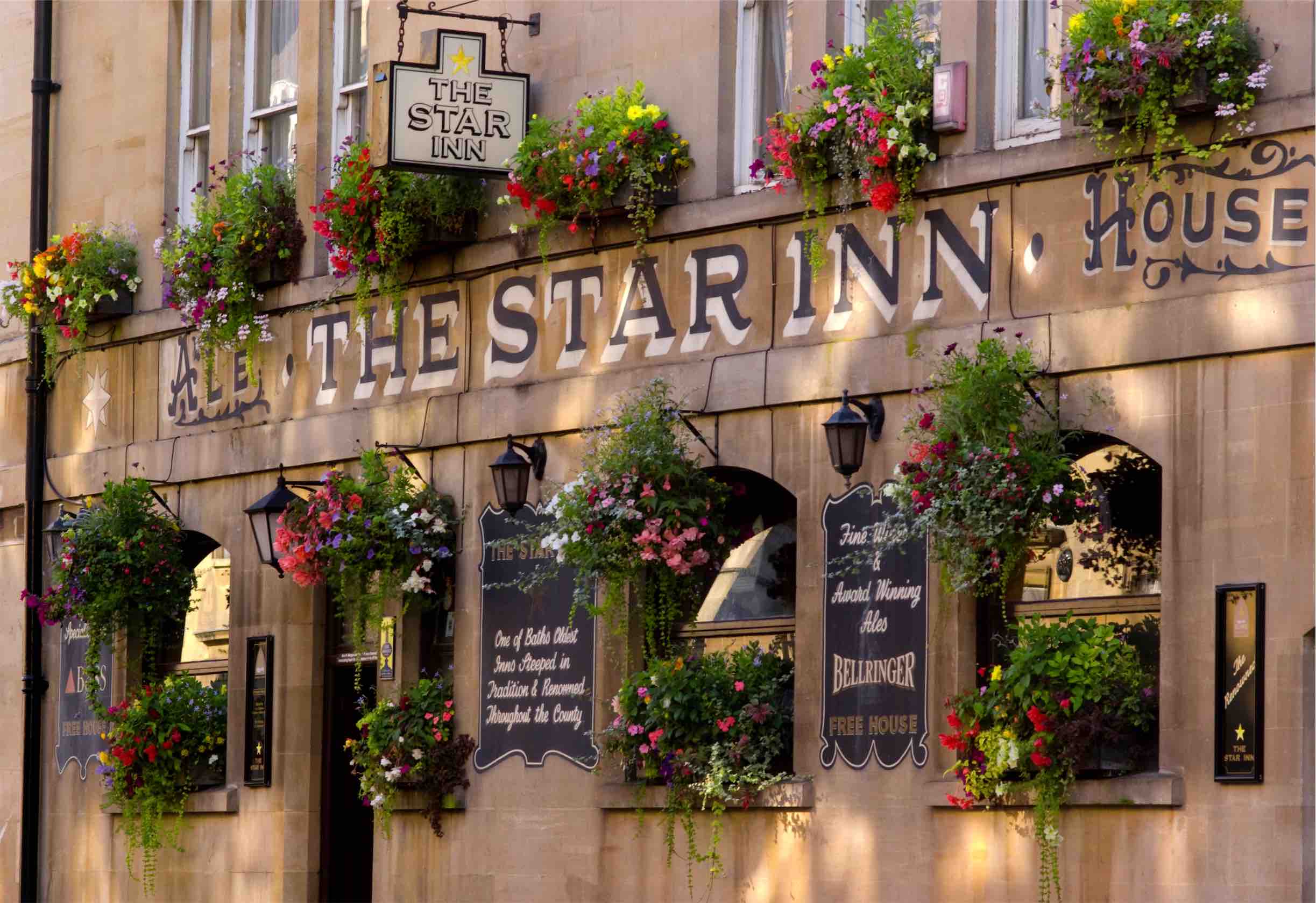 Very close up shot of a building facade with flowers and lettering which says "The Star Inn House"