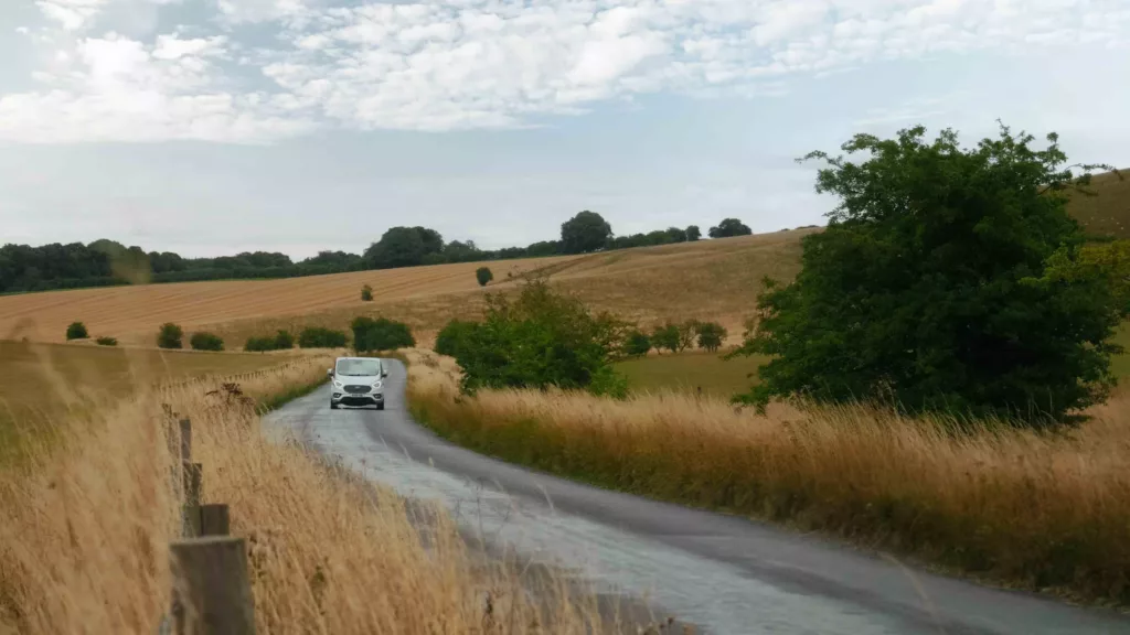 Van moving towards the view surrounded by yellow wheat fields