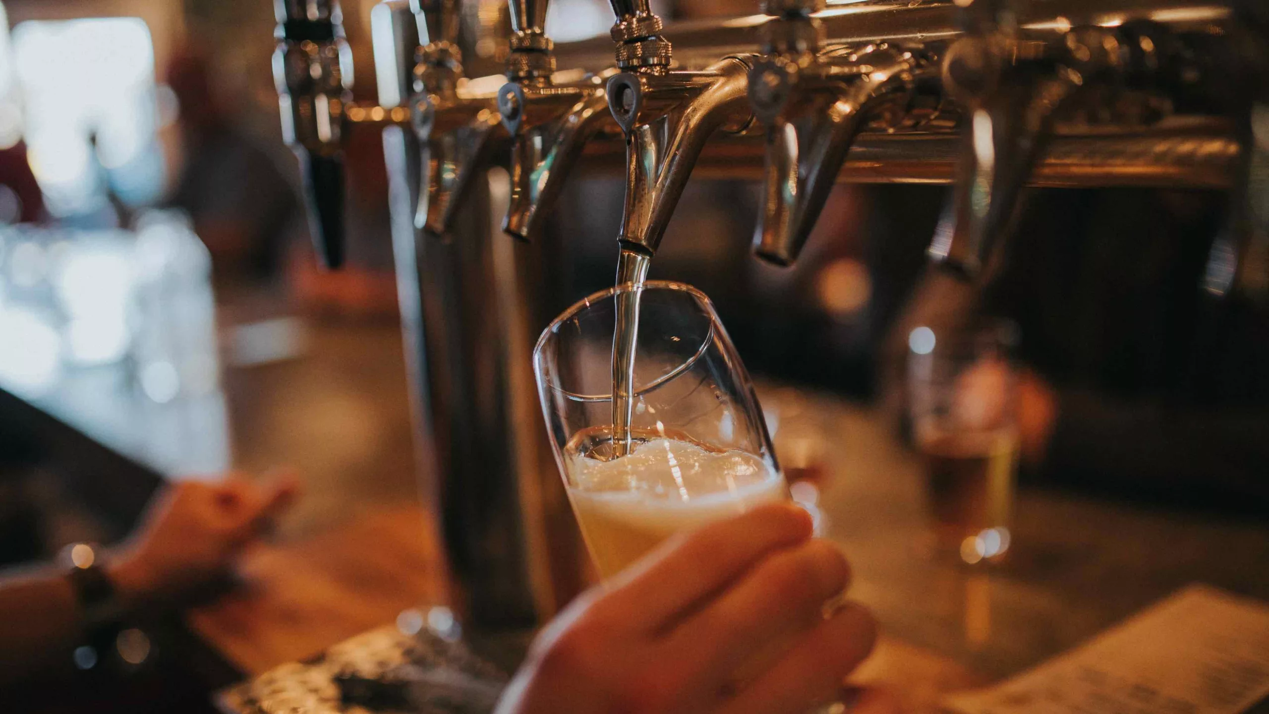 Beer being poured into a glass from the tap at a bar.